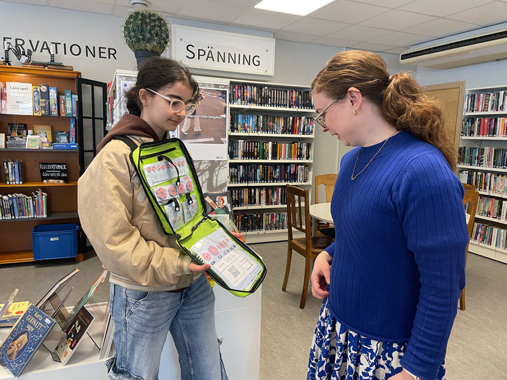 Maria Dandash sålde första majblomman till Mia Olausson på biblioteket i Vaggeryd