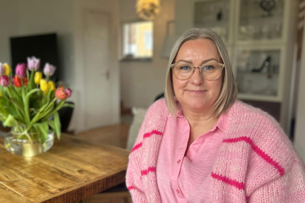 Anetté sitter hemma vid sitt köksbord.