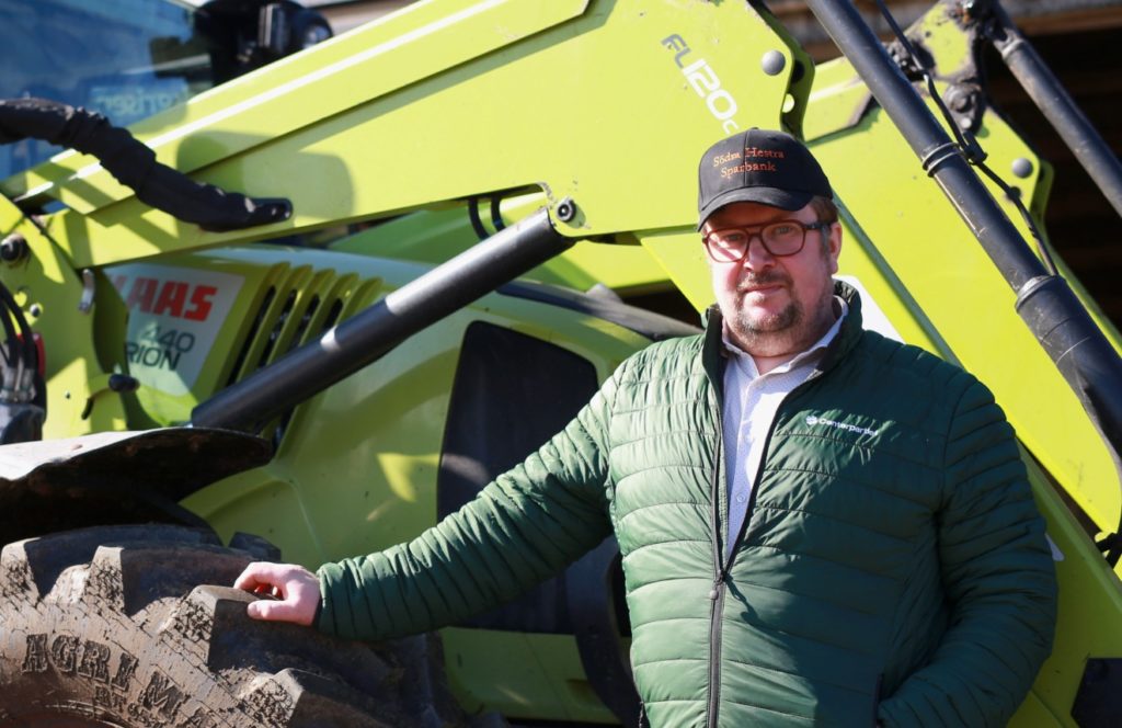 Johan Hilding framför en traktor tittar in i kameran
